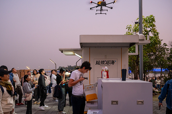 在深圳，外國游客體驗(yàn)無人機(jī)外賣送餐。