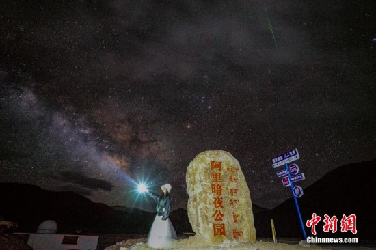 圖為6月20日晚，游客“打卡”西藏阿里暗夜公園，天上是銀河與流星（右上角）。曹枝清 攝