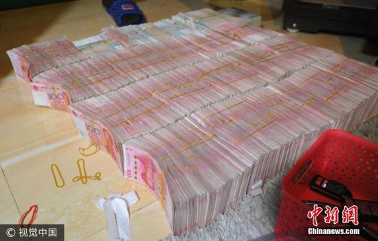 廣西南寧警方8月21日通報，當(dāng)?shù)亟粘晒善粕姘附痤~15.19億元人民幣的特大傳銷案件。圖為當(dāng)場繳獲的成捆現(xiàn)金。圖片來源：視覺中國